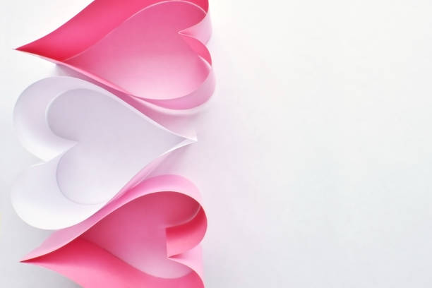 istock Pink and white paper hearts on white background. 992811498