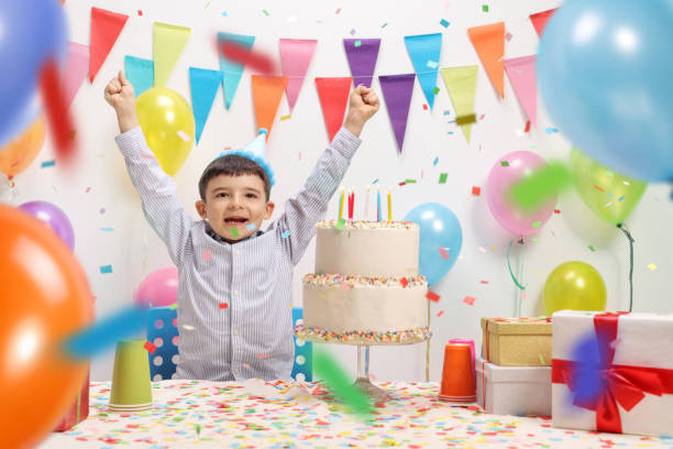 istock Overjoyed kid with a party hat and birthday cake 992814852