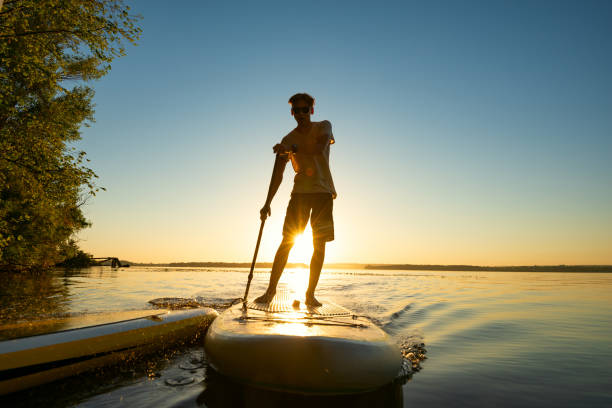 istock The guy sails on a SUP board in a rays of rising sun 992815692