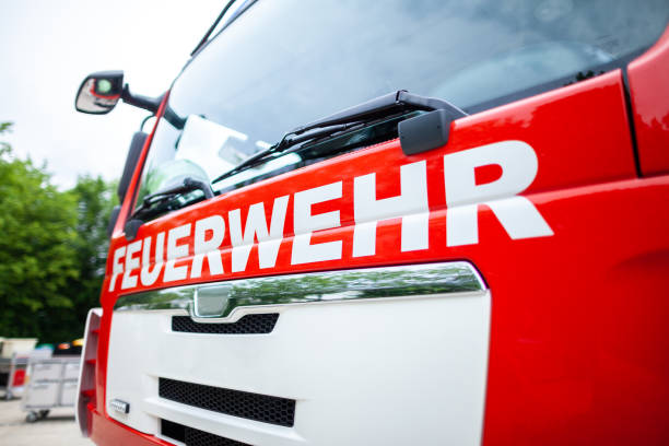 German fire engine stands on a deployment site. The german word Feuerwehr means fire department.