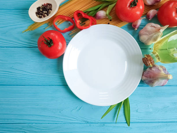 istock spaghetti, tomato, garlic plate on a blue wooden background 992837186