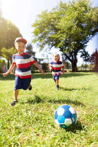 istock Siblings playing soccer in public park 992837908