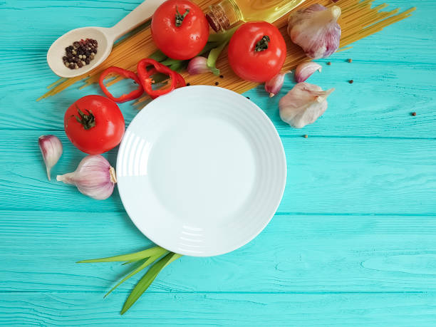 istock spaghetti, tomato, garlic plate on a blue wooden background 992837956