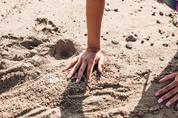 istock Female hands playing with the sand on the beach 992848092