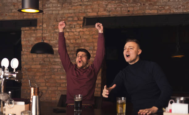 istock Happy friends cheering for favorite team in pub 992848334