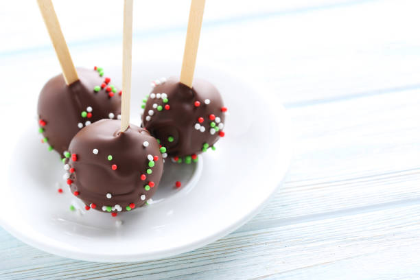 Chocolate cake pops on white wooden table
