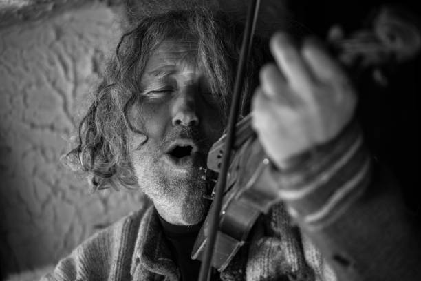 istock Elderly man singing as he plays a violin 992855972