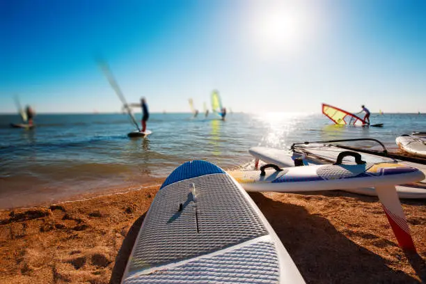 Windsurf boards on the sand at the beach. Windsurfing and active lifestyle.