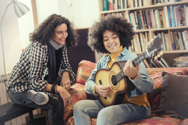 istock Young woman learning playing guitar with Music Teacher 992862458