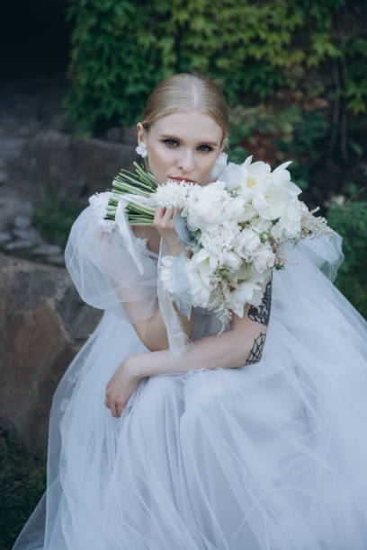 istock beautiful young bride in dress with bouquet looking at camera 992863890