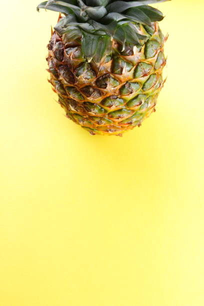 istock Pineapple on a yellow background, tropical fruit top view, pineapple in pop art style, vegetarian food in minimalism style, copy space 992864442