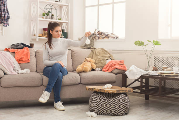 istock Desperate woman sitting on sofa in messy room 992866966