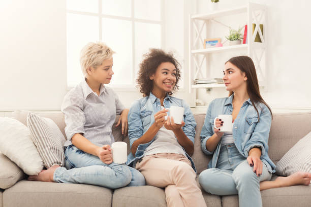 istock Three female friends with coffee chatting at home 992867480