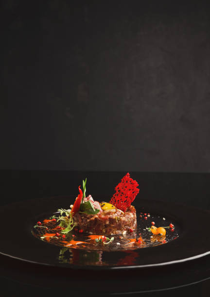 istock Raw veal tartare with sauce on black plate 992868108
