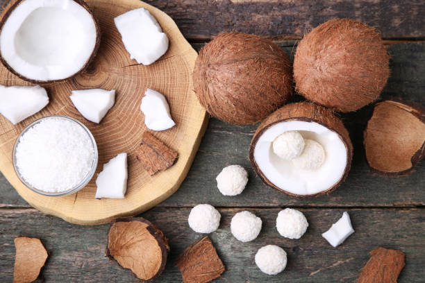 istock Coconuts with candies on grey wooden table 992868262