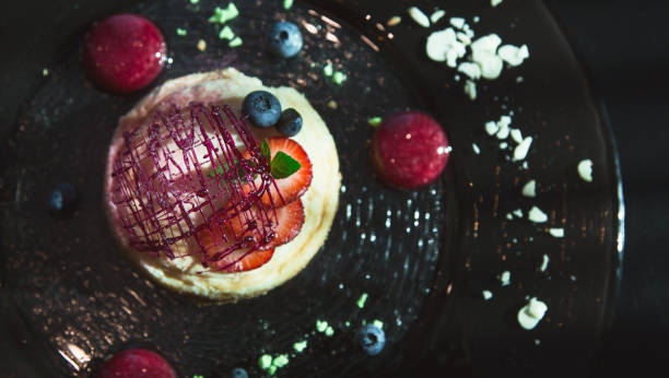 istock Lemon cheesecake with berry spheres served at modern restaurant 992870652