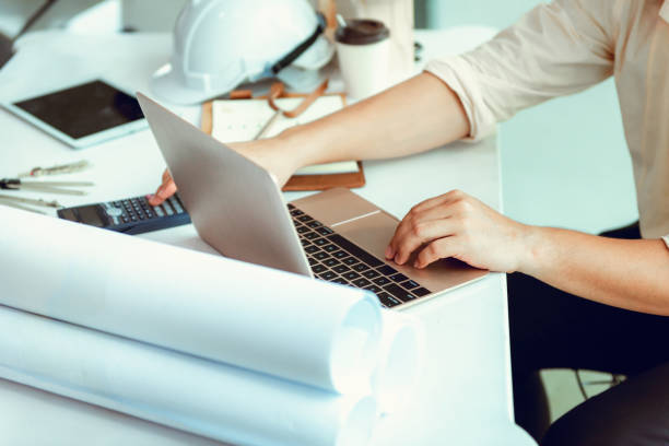 istock Close up portrait of civil engineer using laptop to  planning project schedule, Engineering and construction concept 992872278
