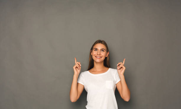 istock Excited woman shows something, point finger up 992878904