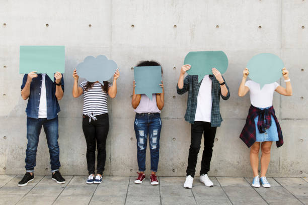 istock Group of young adults outdoors holding empty placard copyspace thought bubbles 992879632