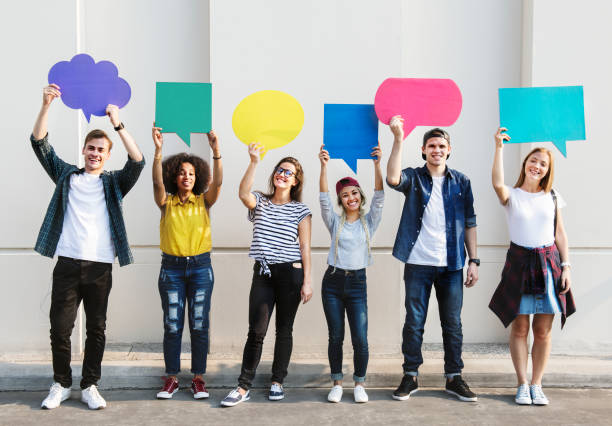 istock Young adult friends holding up copyspace placard thought bubbles 992879812