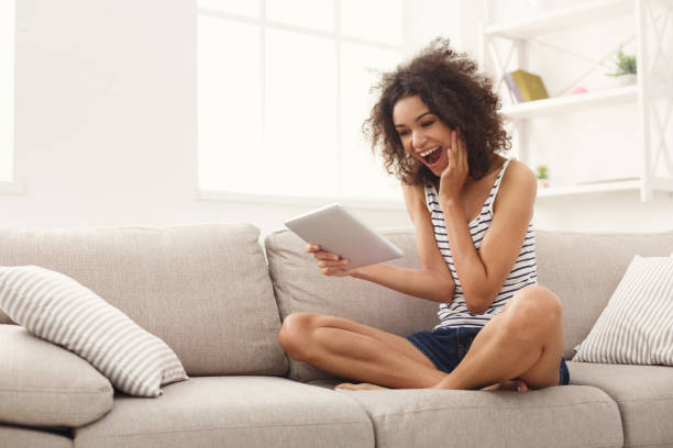 Young excited girl with digital tablet at home
