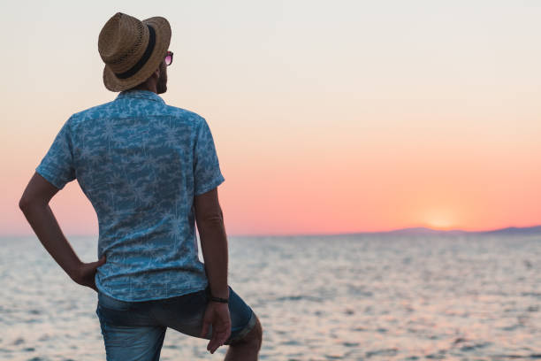 istock Young man enjoying sunset by the sea 992879992