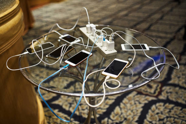 그룹의 테이블에 충전 하는 스마트폰 - mobile phone charging power plug adapter 뉴스 사진 이미지
