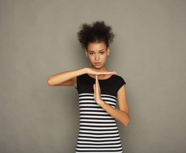 African-american woman making time out gesture Young african-american woman making time out gesture, sign to ask for time, deadline concept, gray studio background time out signal stock pictures, royalty-free photos & images