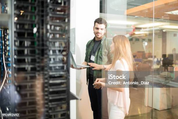 Colleghi Che Discutono Nella Sala Server Di Office - Fotografie stock e altre immagini di Tecnologia - Tecnologia, Server di rete, Sala server