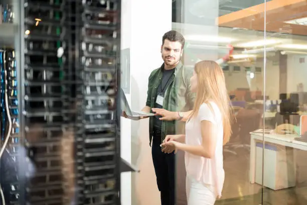 Photo of Colleagues discussing in office server room