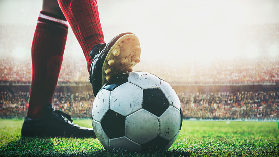 pisan de pies del jugador de fútbol en balón de fútbol para el kick-off en el estadio photo
