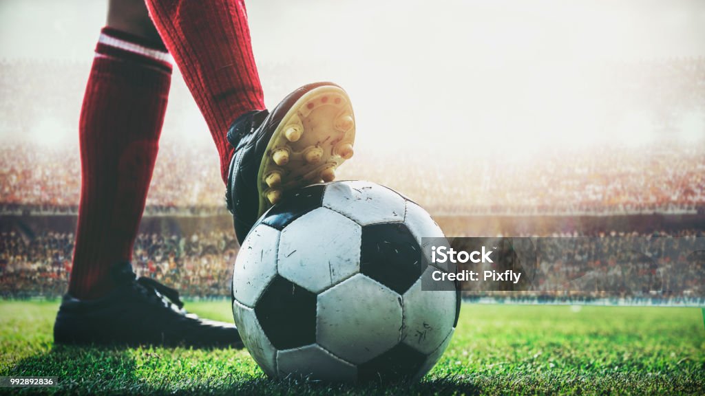 feet of soccer player tread on soccer ball for kick-off in the stadium Soccer Stock Photo