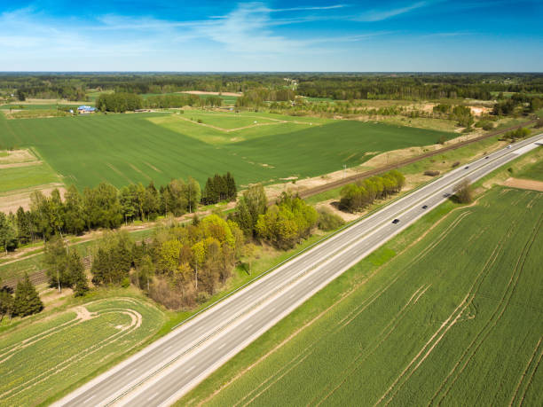 istock High-speed highway and railway, top view. Green field and blue sky. 992893914