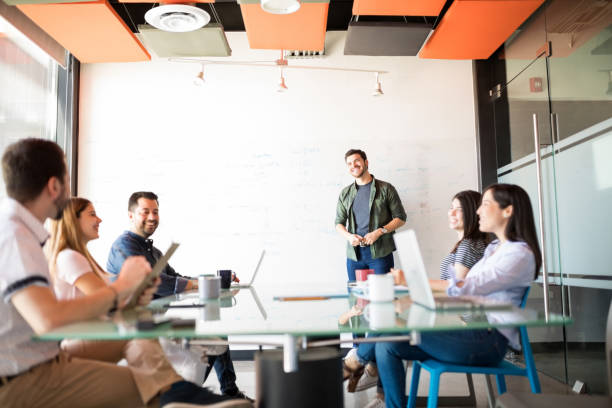 istock Young latin man giving presentation to his colleagues 992894000