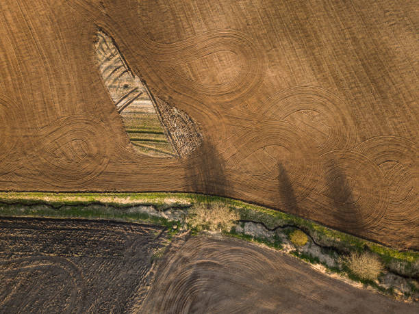 istock Spring arable land. Field and beautiful patterns from the tractor. View from above. 992901174
