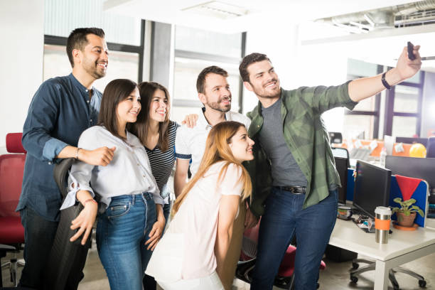 istock Young businessman taking selfie with team in office 992901444