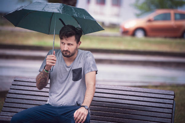 Young Adult Man Waiting for Someone Under The Rain stock photo