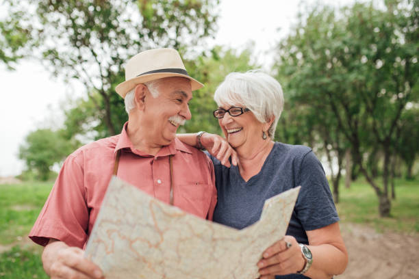 istock Senior married couple holding a map and looking at each other 992906930
