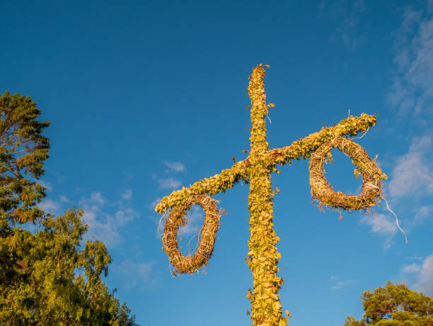 istock Swedish maypole used on midsummer or midsommar in sun set light. Blue sky in background. 992913246