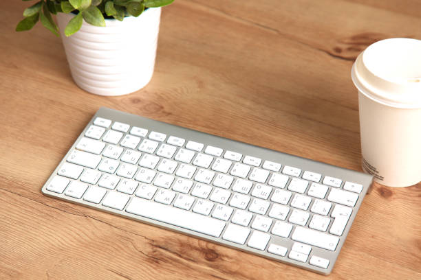 istock Modern aluminum keyboard on the wooden table in the office 992913262