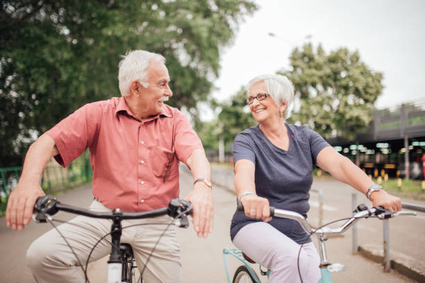 istock Senior married couple looking at each other while riding bicycles 992913412