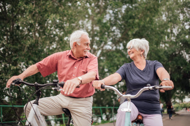 istock Smiling old people cycling in the park 992913430