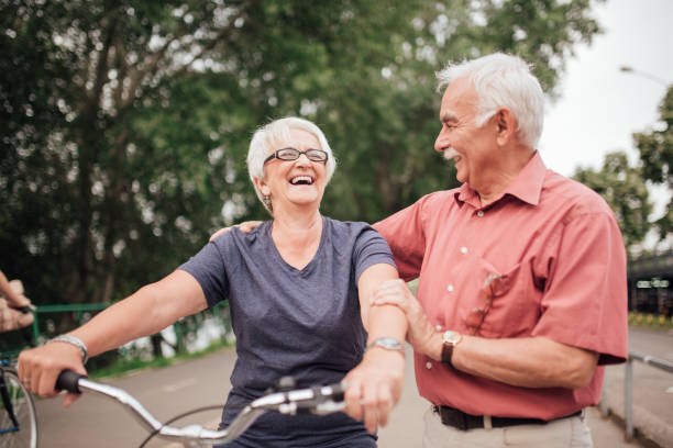 istock Mature couple with a bicycle laughing at the park 992913482