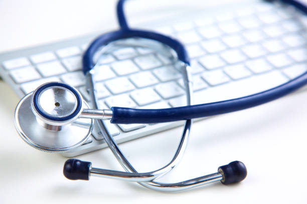 istock A medical stethoscope near a laptop on table, on white 992923312