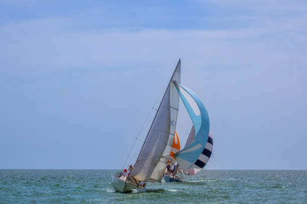 Sunny weather in the open sea. Three sailing yachts with spinnakers going with a significant tilt