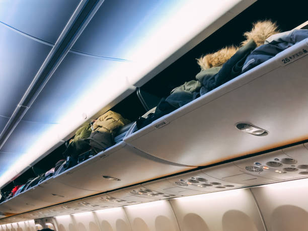 istock Over head luggage compartment in the airplane 992943006