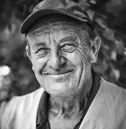 Portrait of smiling old man with wrinkled face. Black and white portrait .