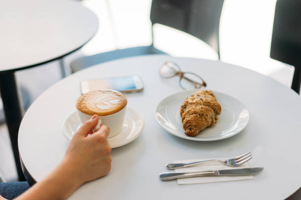 Lady's hands holding cup with sth heart-shaped