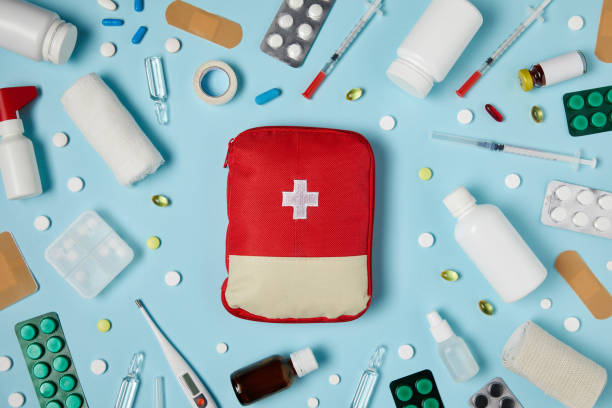 istock top view of red first aid kit bag on blue surface surrounded with different medicines 992956644
