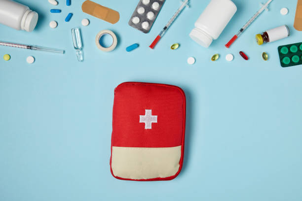 istock top view of red first aid kit bag on blue surface with different medicines 992959066